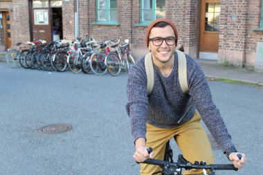 Şehirde bisiklet süren şık bir etnik adam.