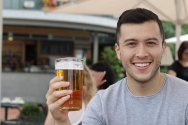 Yakışıklı erkek soğuk bir bardak birayla tezahürat yapıyor.