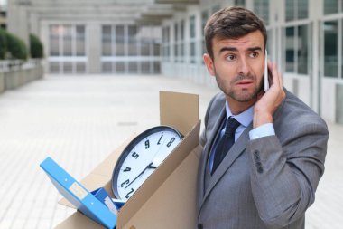 Depresyondaki işadamı eşyalarını taşıyor.