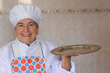 Son sınıf öğrencisi mutfakta dikiliyor, yakın plan bir portre. 