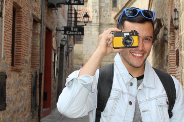 Klasik kamerayla fotoğraf çekmek için yaratıcılığını kullanan bir adam.