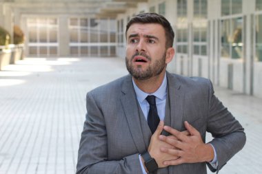 Sokakta gri takım elbiseli yakışıklı genç işadamının yakın plan portresi.