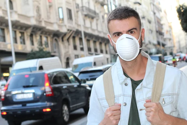 close-up portrait of handsome young man in medical safety mask on street