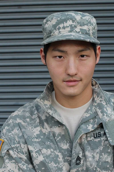 close-up portrait of handsome young asian us army soldier in front of wall