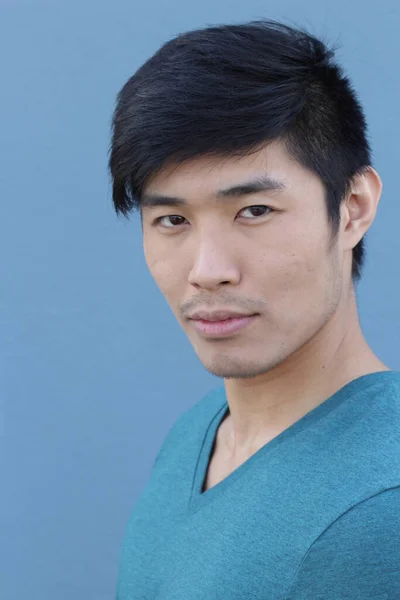 年轻英俊的亚洲男子在蓝色墙壁前的特写 — 图库照片