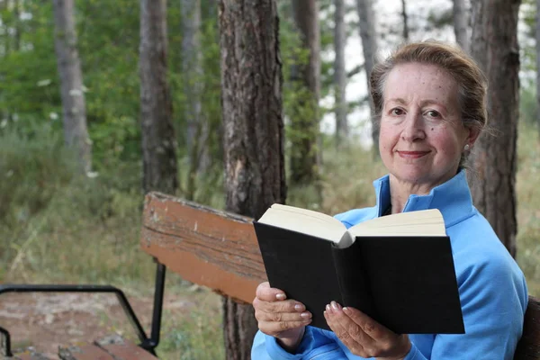 Senior Woman Relaxing Park Bench Κρατώντας Ένα Βιβλίο — Φωτογραφία Αρχείου