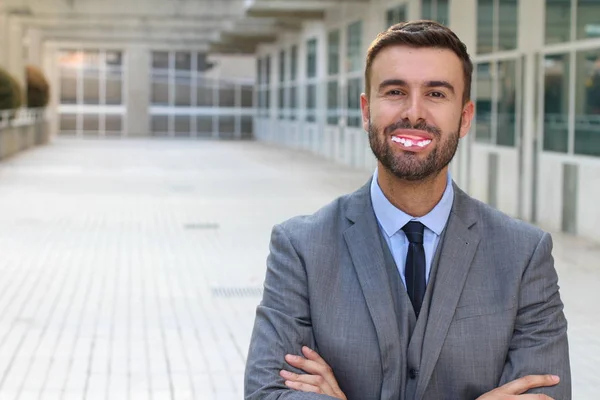 close-up portrait of handsome young businessman with masquerade teeth on street