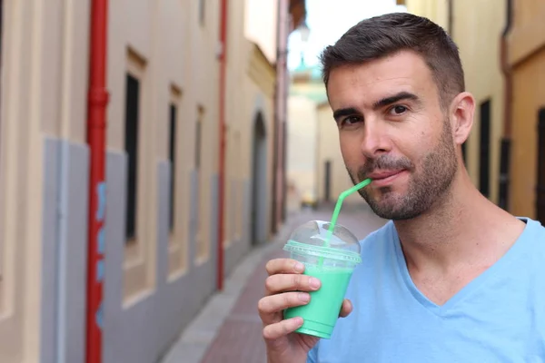 Cute man drinking a shake outdoors