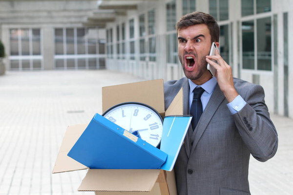 Депрессивный бизнесмен несет свои вещи
