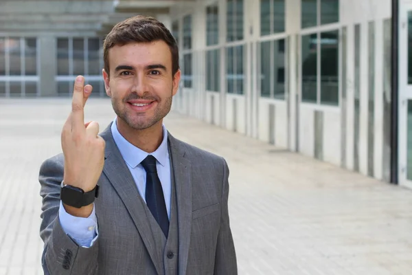 路上で指を渡っているハンサムな若いビジネスマンの肖像画です — ストック写真