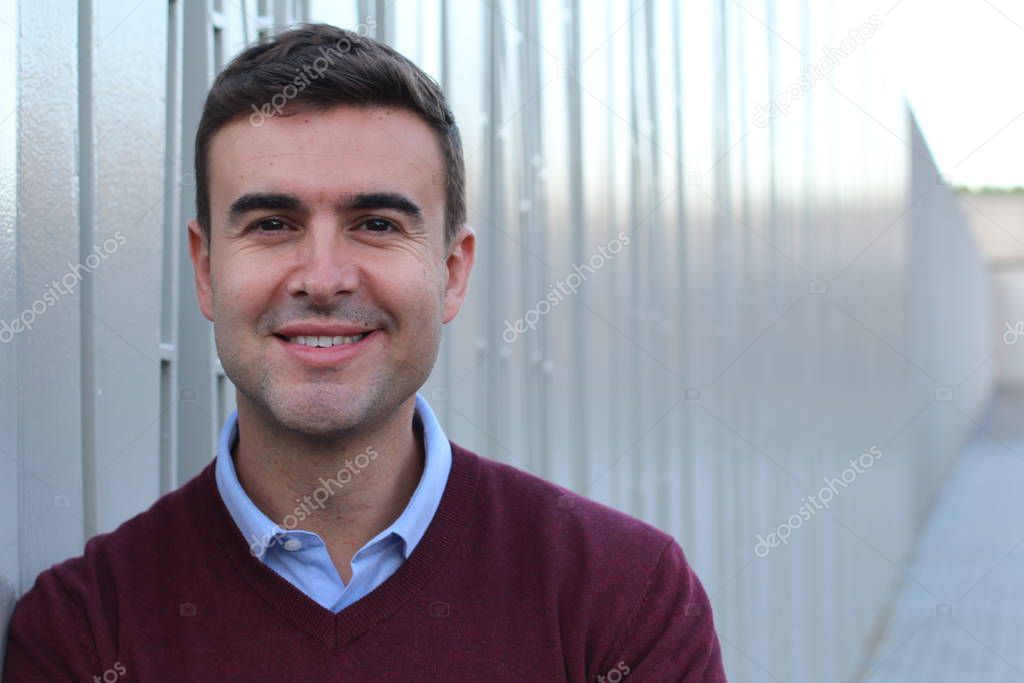 close-up portrait of handsome young man in casual clothes in front of metal wall