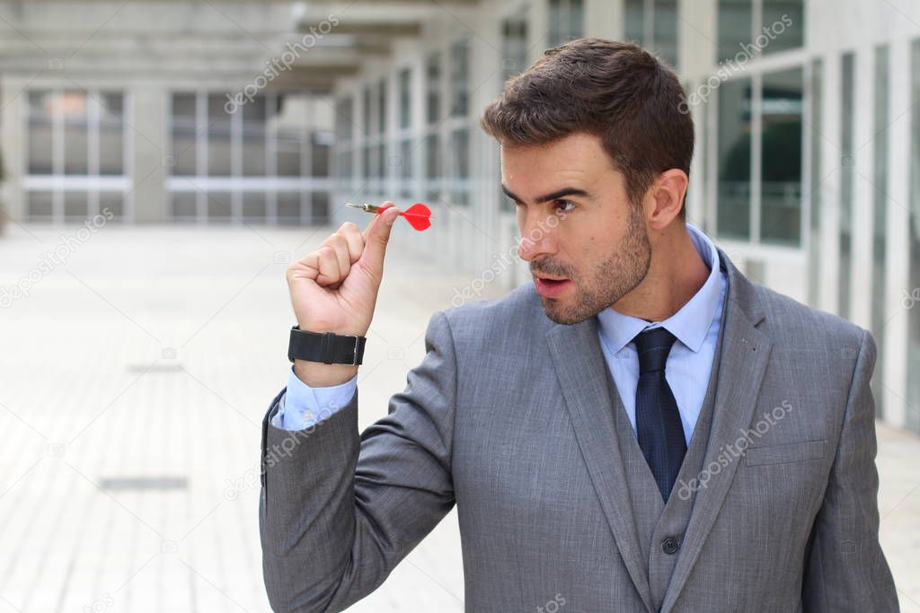 Impulsive businessman playing darts in office space
