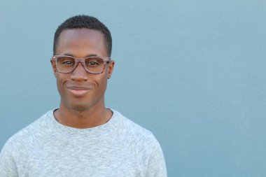 Mavi duvarın önündeki yakışıklı Afro-Amerikan 'ın yakın plan portresi.