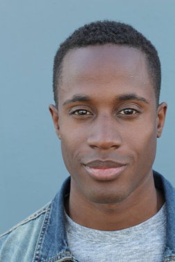 Mavi duvarın önündeki yakışıklı Afro-Amerikan 'ın yakın plan portresi.