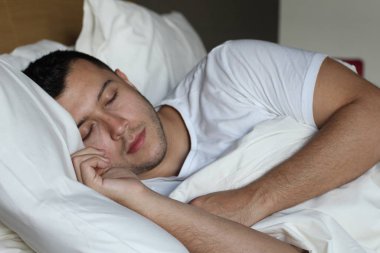 Etnik adam rahat bir yatakta derin bir uyku çekti.