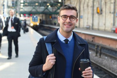 İş adamı retro tren istasyonunda yürüyor