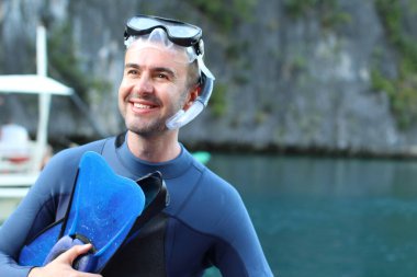 Teknede şnorkel ve maskeli yakışıklı genç adamın yakın plan portresi.