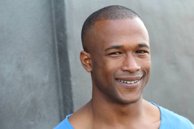 Sokakta mavi tişörtlü yakışıklı Afro-Amerikan adamın yakın plan portresi.