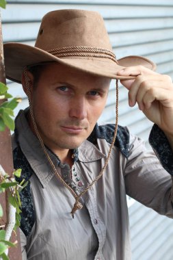 Kovboy şapkalı yakışıklı genç adamın yakın plan portresi.