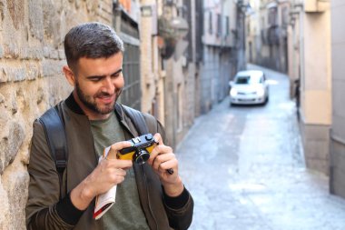 Eski şehir caddesinde kameralı yakışıklı bir gencin yakın plan portresi.