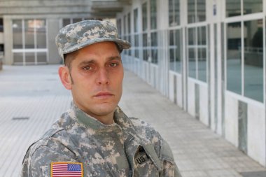 Sokaktaki üniformalı yakışıklı genç askerin yakın plan portresi.