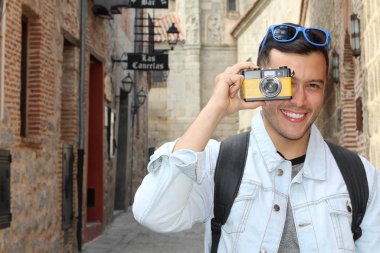 Klasik kamerayla fotoğraf çekmek için yaratıcılığını kullanan bir adam.