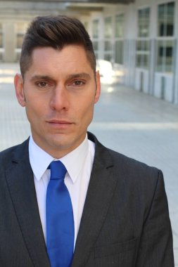 close-up portrait of handsome young businessman in suit on street