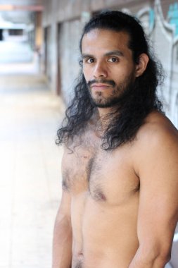 close-up portrait of handsome young mixed race shirtless man on street