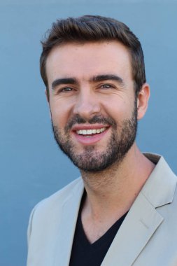 Duvarın önündeki yakışıklı sakallı adamın yakın plan portresi.