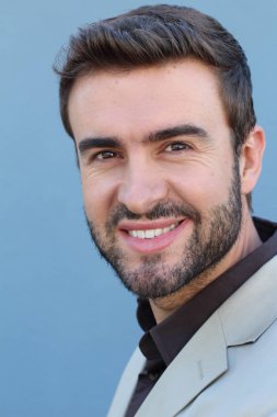 Duvarın önündeki yakışıklı sakallı adamın yakın plan portresi.