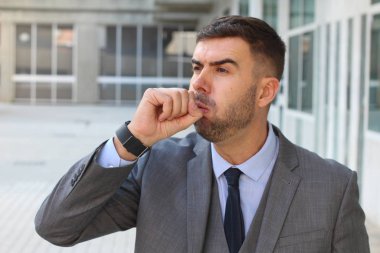 Sokakta öksüren yakışıklı genç iş adamının yakın plan portresi.