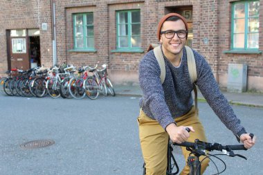 Şehirde bisiklet süren şık bir etnik adam.