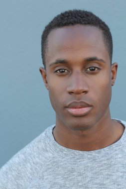 Mavi duvarın önündeki yakışıklı Afro-Amerikan 'ın yakın plan portresi.