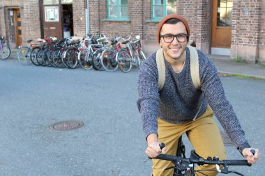 Şehirde bisiklet süren şık bir etnik adam.