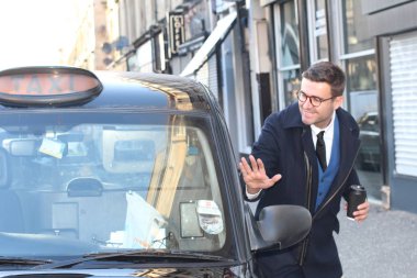 Sokakta taksiye binen yakışıklı genç adamın yakın plan portresi.