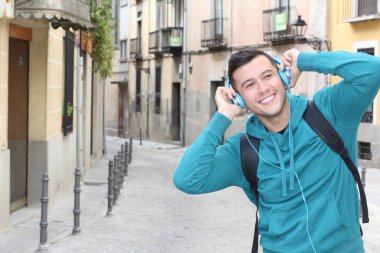 Genç etnik adam dışarıda teknoloji kullanıyor.