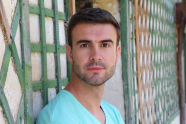 Caddedeki mavi tişörtlü yakışıklı genç adamın yakın plan portresi.