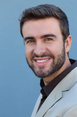 Duvarın önündeki yakışıklı sakallı adamın yakın plan portresi.