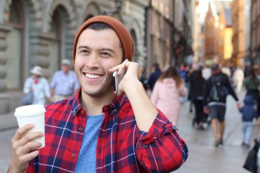 close-up portrait of handsome young man talking by phone on street