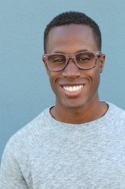 Mavi duvarın önündeki yakışıklı Afro-Amerikan 'ın yakın plan portresi.