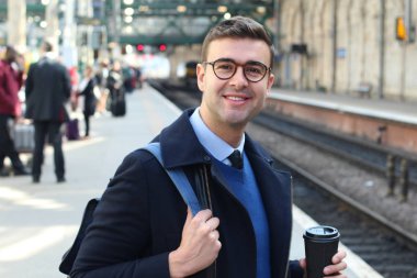 İş adamı retro tren istasyonunda yürüyor