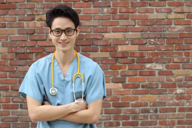 Sokakta steteskopu olan yakışıklı Asyalı genç bir doktorun yakın plan portresi.