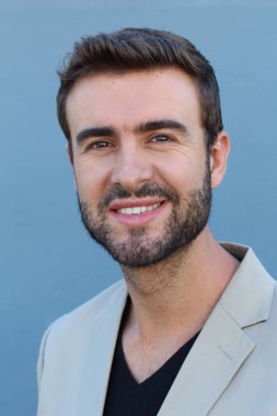 Duvarın önündeki yakışıklı sakallı adamın yakın plan portresi.