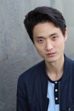 Tarafsız ifadeli Asyalı adam. Yakın plan.