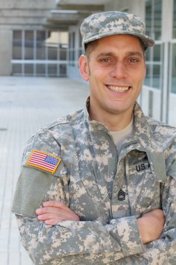 Sokaktaki üniformalı yakışıklı genç askerin yakın plan portresi.