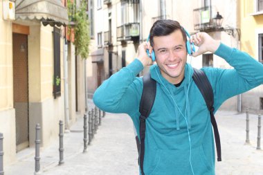 Genç etnik adam dışarıda teknoloji kullanıyor.