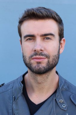 Duvarın önündeki yakışıklı sakallı adamın yakın plan portresi.