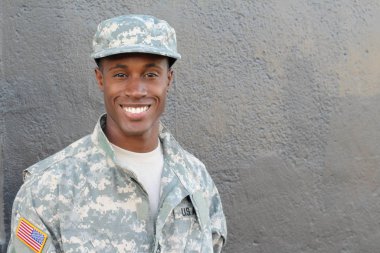 Gri duvarın önündeki yakışıklı Afro-Amerikan askerinin yakın plan portresi.