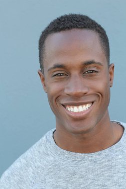 Mavi duvarın önündeki yakışıklı Afro-Amerikan 'ın yakın plan portresi.
