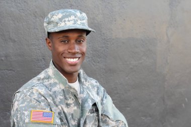 Gri duvarın önündeki yakışıklı Afro-Amerikan askerinin yakın plan portresi.